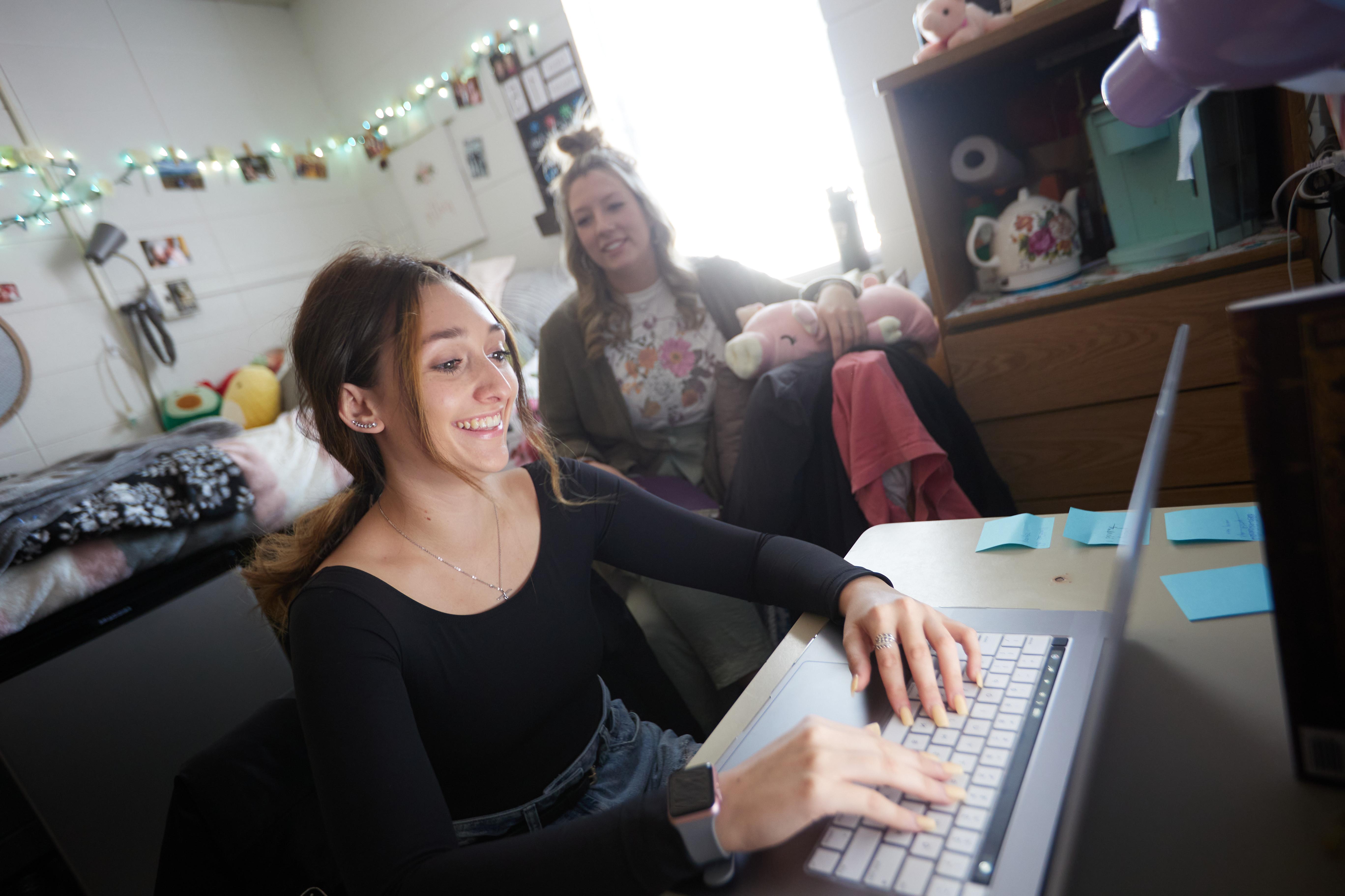Female student using computer in dorm room
